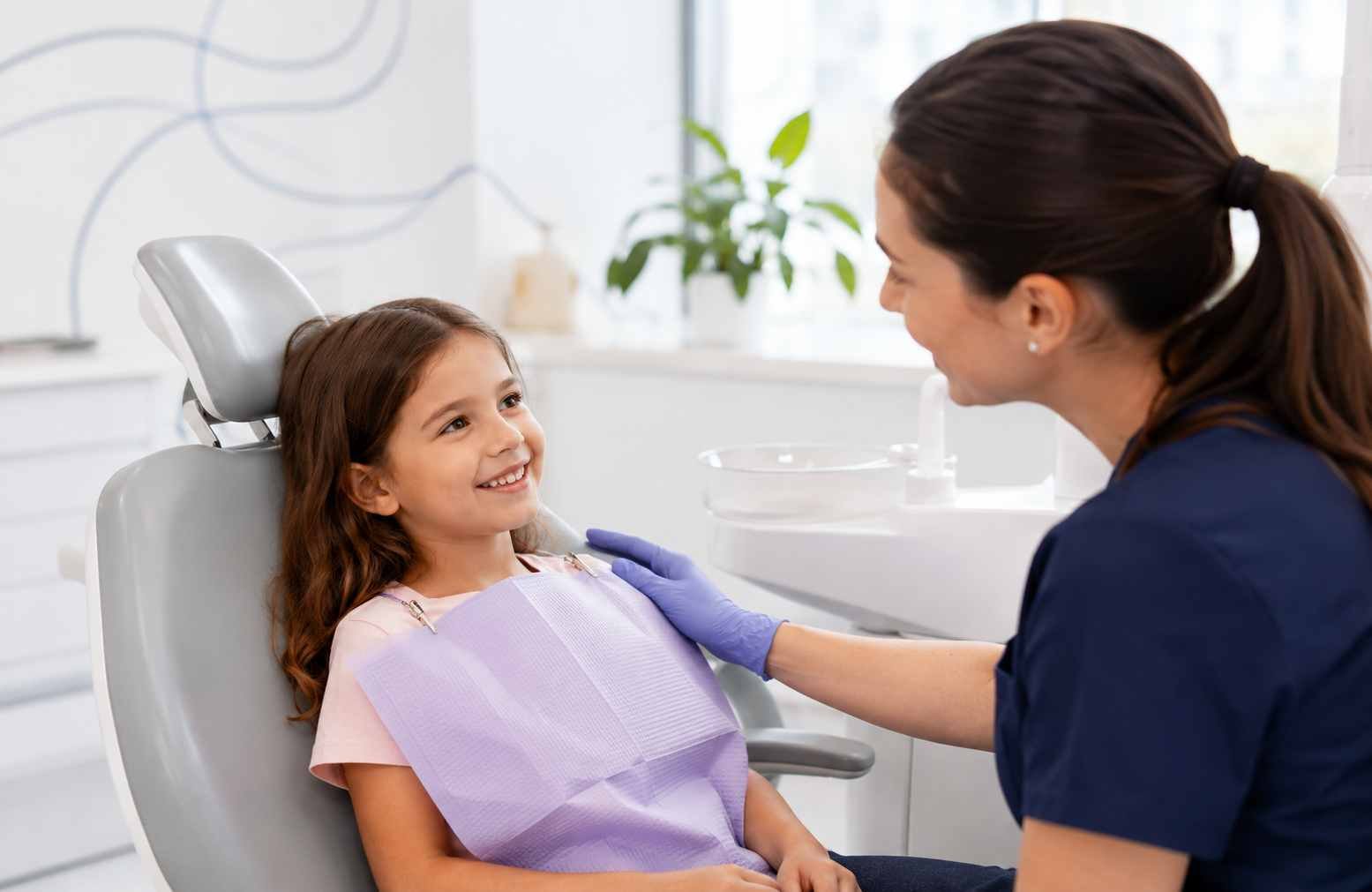 Gentle Bradford children's dentist demonstrating a tooth model to a smiling young child